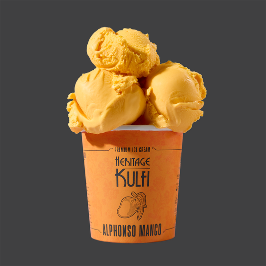 3 scoops of mango-colored kulfi sit atop an orange pint container with a mango icon on the front