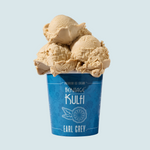 3 scoops of earl grey kulfi sit atop a bright blue pint container with an earl grey icon on the front