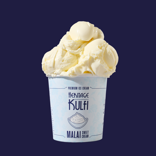 3 scoops of creamy white kulfi sit atop a light blue pint container with a bowl of sweet cream icon on the front