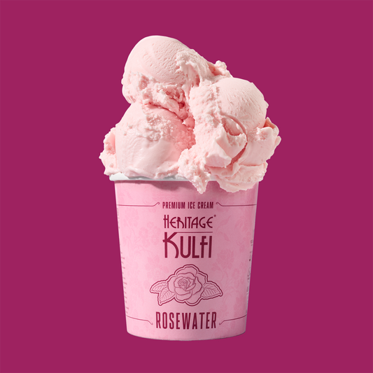 3 scoops of rose-colored kulfi sit atop a light link pint container with a rose icon on the front