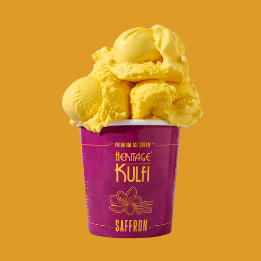 3 scoops of saffron kulfi sit atop a pink pint container with a saffron icon on the front