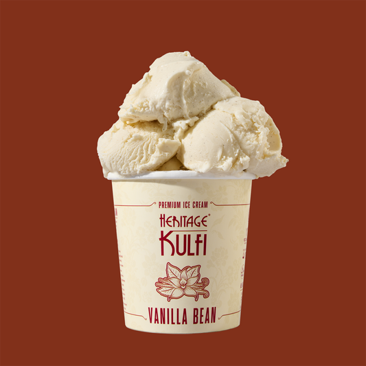 3 scoops of vanilla kulfi sit atop a white pint container with a vanilla icon on the front
